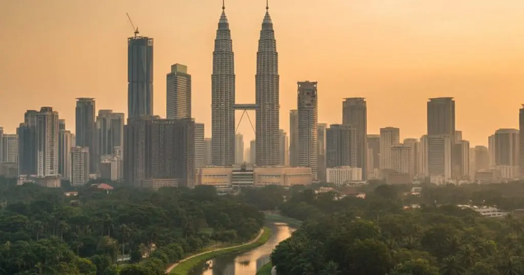 Kuala Lumpur skyline at dusk, showing urban development and natural elements, illustrating MM2H environmental impact
