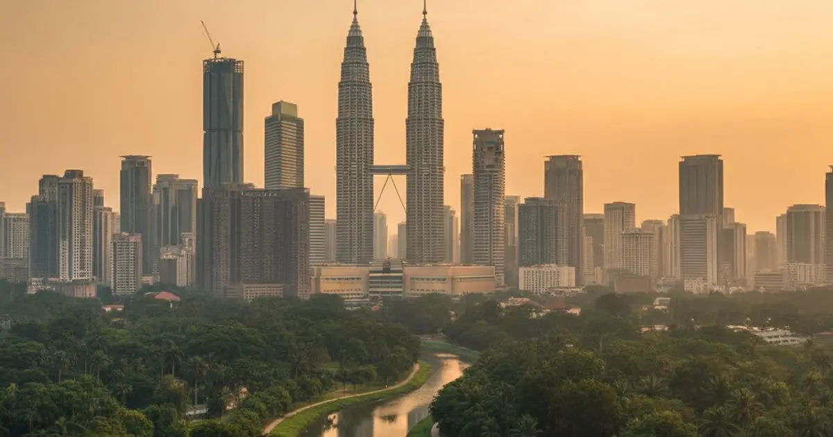 Kuala Lumpur skyline at dusk, showing urban development and natural elements, illustrating MM2H environmental impact